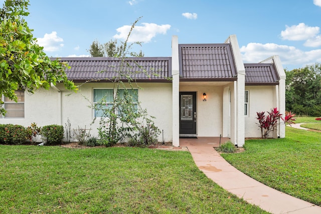 206 Lake Susan Ln, West Palm Beach, FL 33411 - townhome / multi-family property with mansard roof, a front lawn, and stucco siding