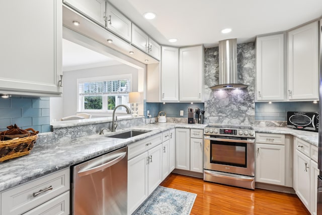 206 Lake Susan Ln, West Palm Beach, FL 33411 - kitchen with light wood-type flooring, a sink, stainless steel appliances, white cabinets, and wall chimney range hood