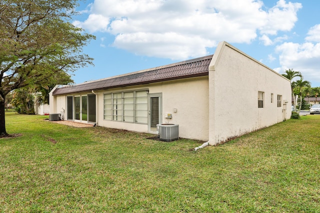 206 Lake Susan Ln, West Palm Beach, FL 33411 - back of house with stucco siding, a lawn, cooling unit, and a tiled roof