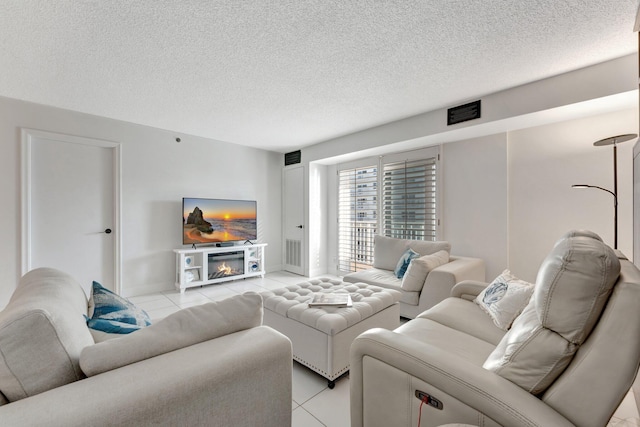 living room with light tile patterned floors, visible vents, and a textured ceiling