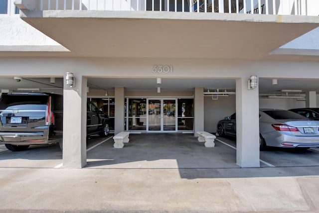view of exterior entry with a balcony and french doors