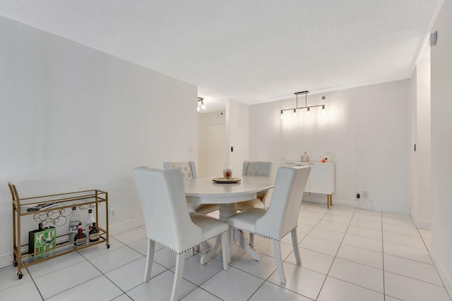 dining area featuring light tile patterned floors and baseboards