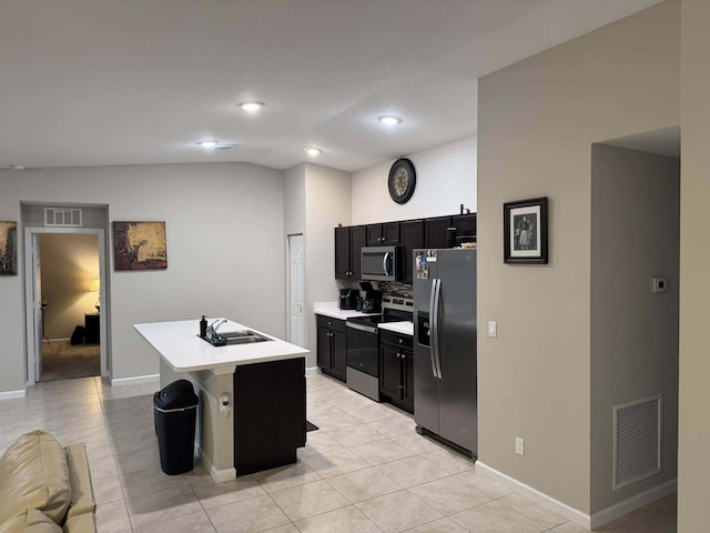 kitchen featuring light countertops, visible vents, dark cabinetry, appliances with stainless steel finishes, and a sink
