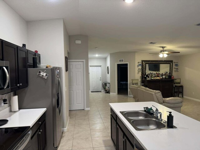kitchen with open floor plan, light countertops, a sink, and ceiling fan