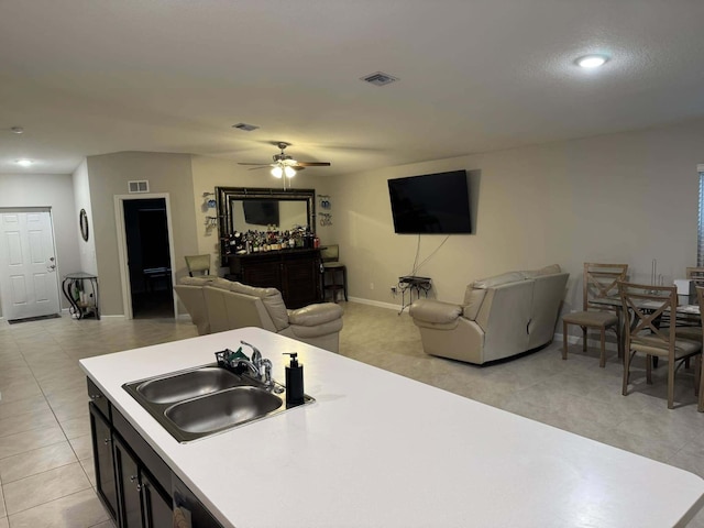 kitchen featuring open floor plan, light countertops, a ceiling fan, visible vents, and a sink