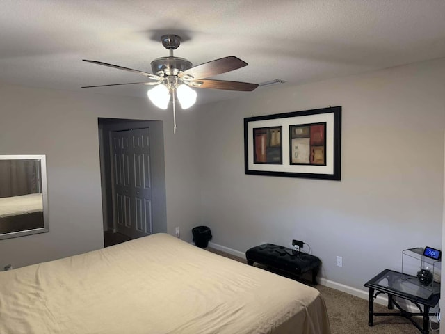 carpeted bedroom featuring a closet, visible vents, baseboards, and a ceiling fan