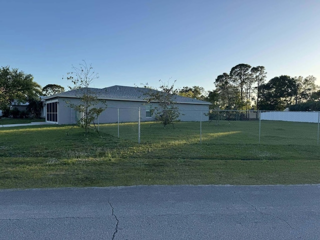 view of side of property with a yard, fence, and stucco siding