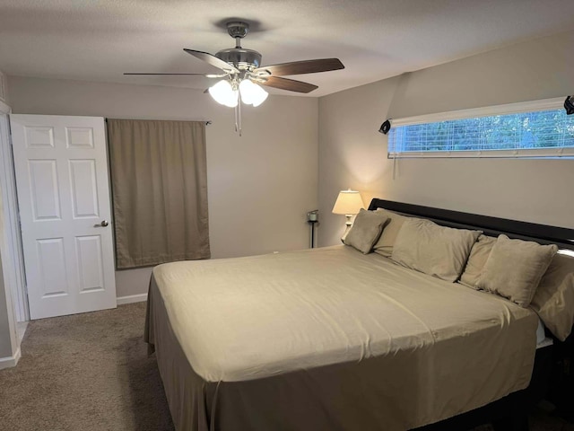bedroom with baseboards, dark carpet, and a ceiling fan