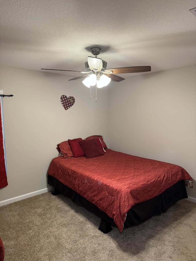 bedroom featuring a textured ceiling, carpet flooring, baseboards, and a ceiling fan