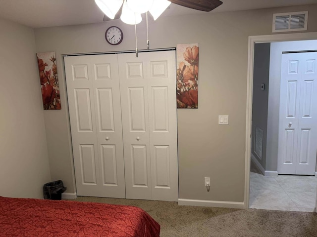 bedroom with a closet, a ceiling fan, visible vents, carpet floors, and baseboards