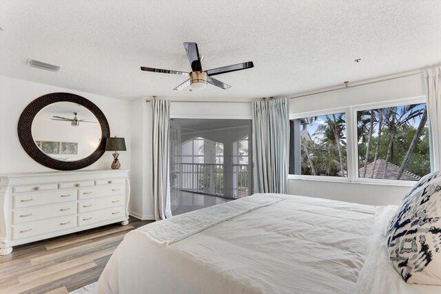 1000 N US Highway 1 Unit 656, Jupiter, FL 33477 - bedroom featuring access to exterior, visible vents, a textured ceiling, and wood finished floors