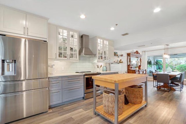 1000 N US Highway 1 Unit 656, Jupiter, FL 33477 - kitchen with wall chimney range hood, white cabinets, gray cabinetry, visible vents, and appliances with stainless steel finishes