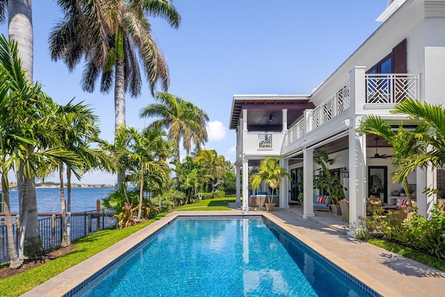pool featuring ceiling fan, a patio, a water view, and fence
