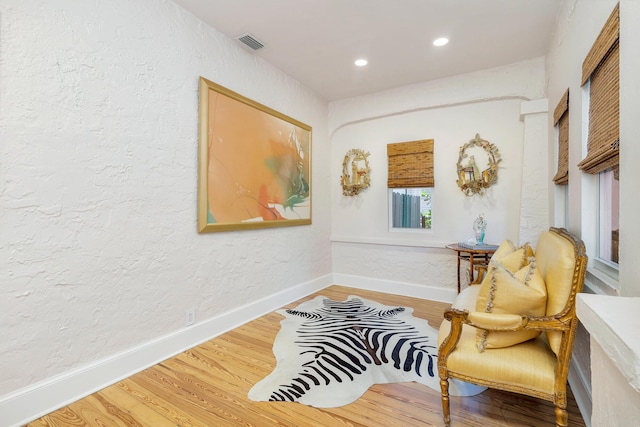 426 30th St, West Palm Beach, FL 33407 - living room with wood finished floors, wallpapered walls, visible vents, baseboards, and arched walkways