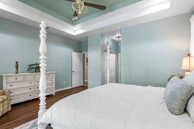 2999 Dovedale Ct, Wellington, FL 33414 - bedroom featuring baseboards, a tray ceiling, wood finished floors, and connected bathroom