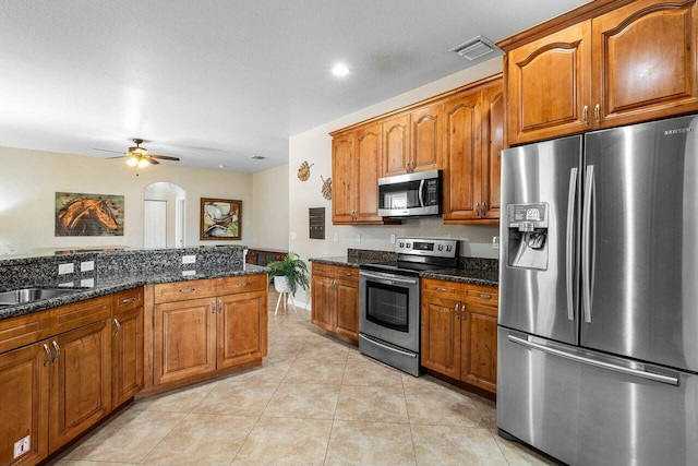 2999 Dovedale Ct, Wellington, FL 33414 - kitchen featuring a sink, brown cabinets, stainless steel appliances, and a ceiling fan