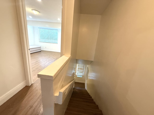 stairway with baseboards, wood finished floors, and visible vents