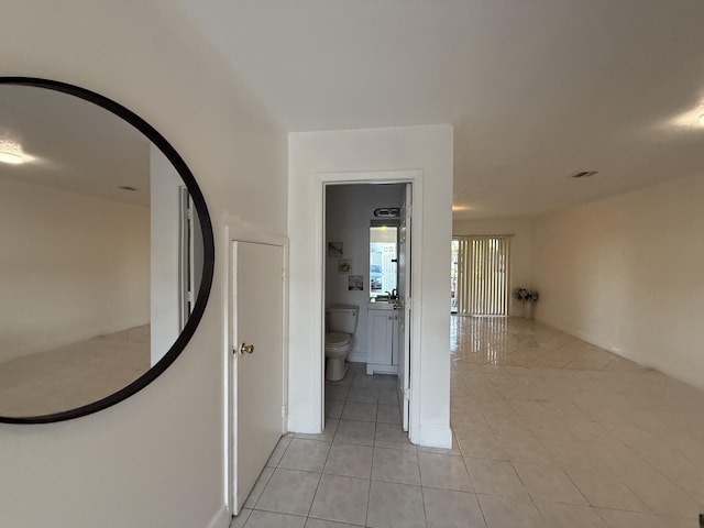 corridor featuring visible vents and light tile patterned floors