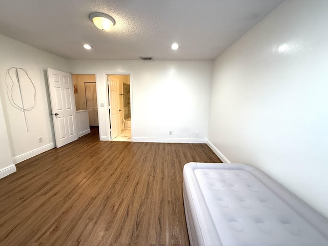 unfurnished bedroom featuring baseboards, dark wood-style floors, and recessed lighting