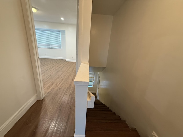 staircase featuring baseboards and wood finished floors