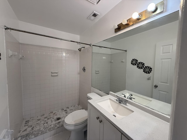 full bath with vanity, a tile shower, toilet, tile patterned flooring, and visible vents