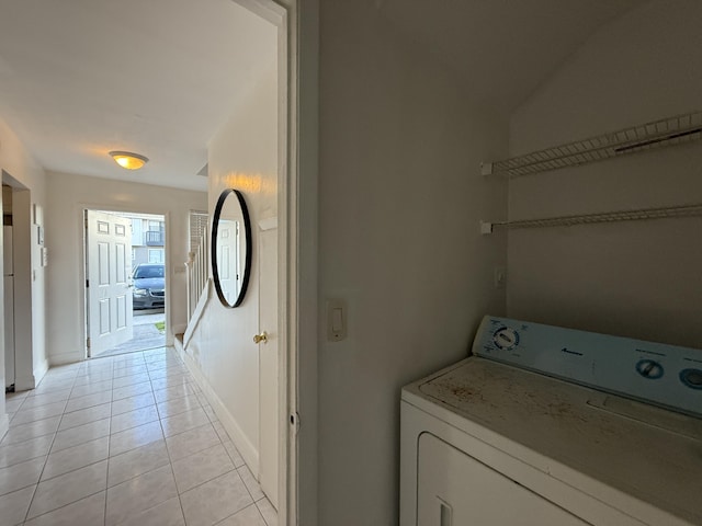 laundry area featuring baseboards, washer / clothes dryer, laundry area, and light tile patterned floors