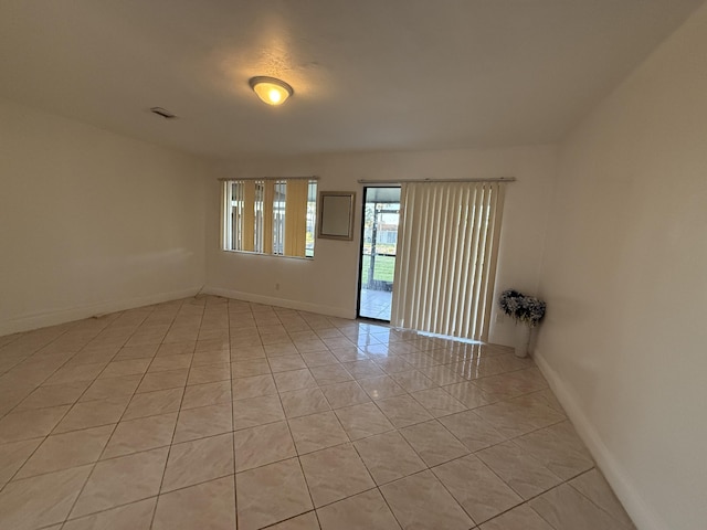 spare room with baseboards, visible vents, and light tile patterned floors