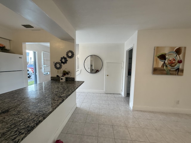 interior space with visible vents, baseboards, and light tile patterned floors