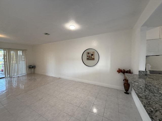 unfurnished room with visible vents, baseboards, and light tile patterned floors