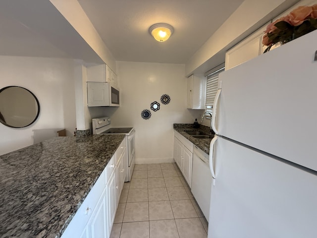kitchen with white cabinets, baseboards, a sink, and white appliances