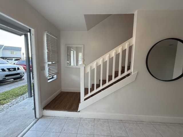 staircase featuring tile patterned floors and baseboards