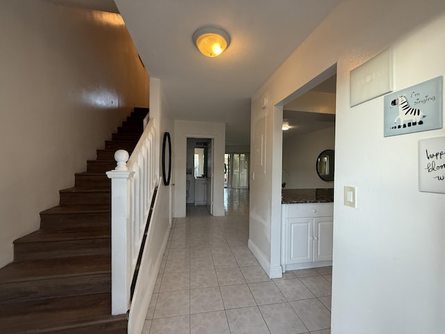 hallway with stairs and light tile patterned floors