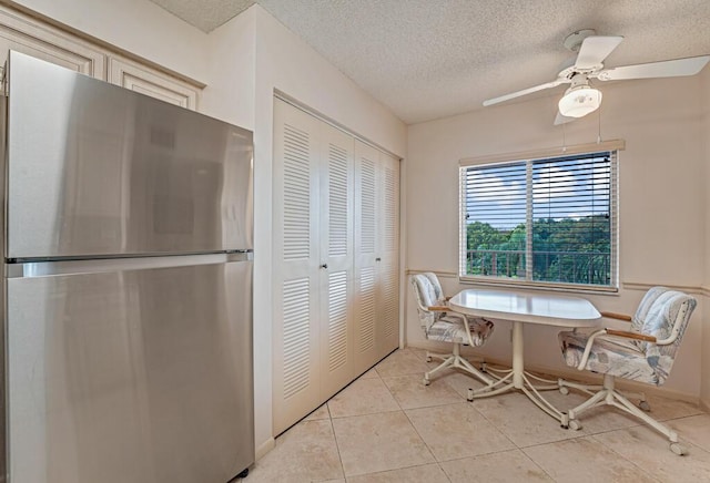 dining area with a textured ceiling, ceiling fan, and light tile patterned floors