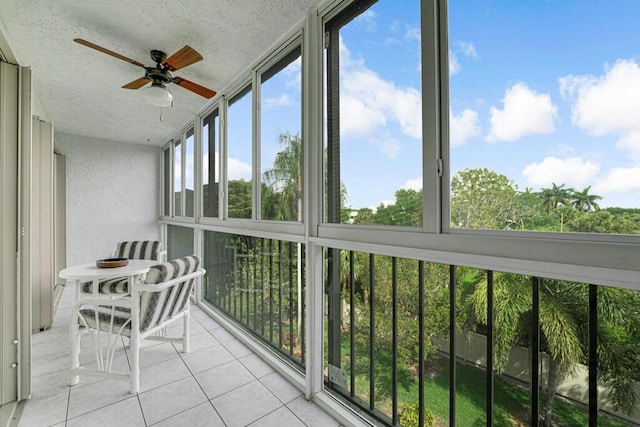 sunroom / solarium featuring tile patterned floors, a textured wall, and a textured ceiling
