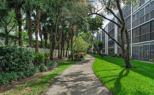 view of community featuring fence and a yard