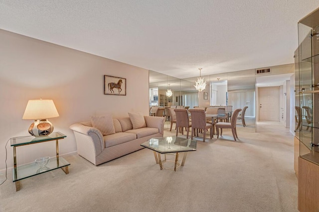 living area with a textured ceiling, visible vents, an inviting chandelier, and light carpet