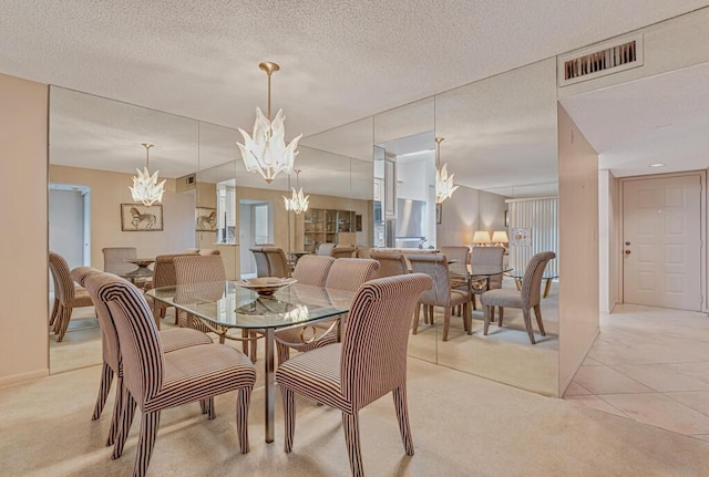 dining area with a textured ceiling, visible vents, an inviting chandelier, and light colored carpet