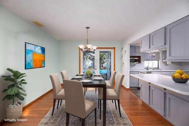 dining space featuring a notable chandelier, dark wood-style floors, baseboards, and visible vents