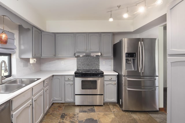 kitchen with a sink, tasteful backsplash, gray cabinetry, under cabinet range hood, and stainless steel appliances