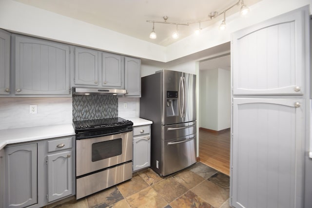 kitchen featuring decorative backsplash, light countertops, appliances with stainless steel finishes, under cabinet range hood, and gray cabinetry