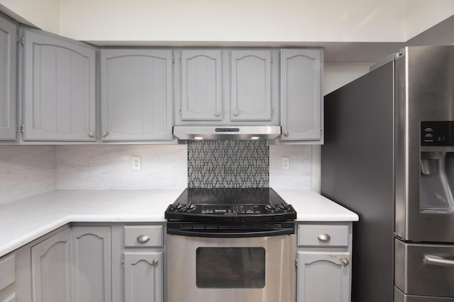 kitchen featuring light countertops, under cabinet range hood, backsplash, and stainless steel appliances