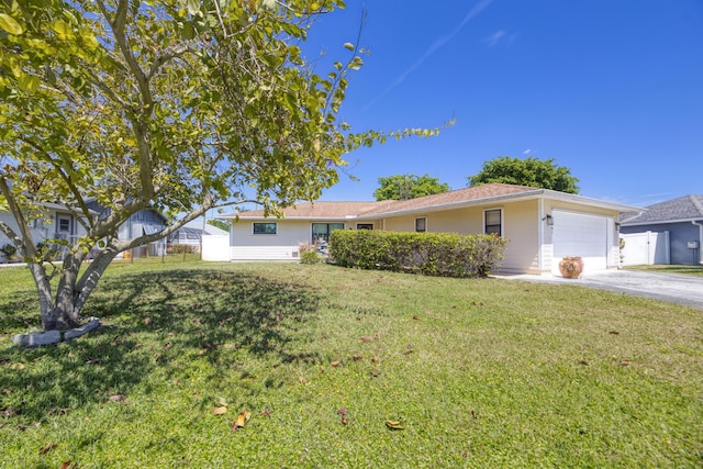single story home with driveway, a front lawn, fence, and an attached garage
