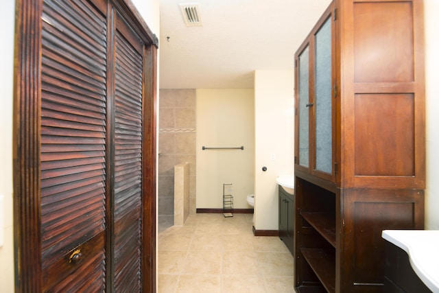 bathroom with tile patterned floors, a closet, toilet, vanity, and visible vents