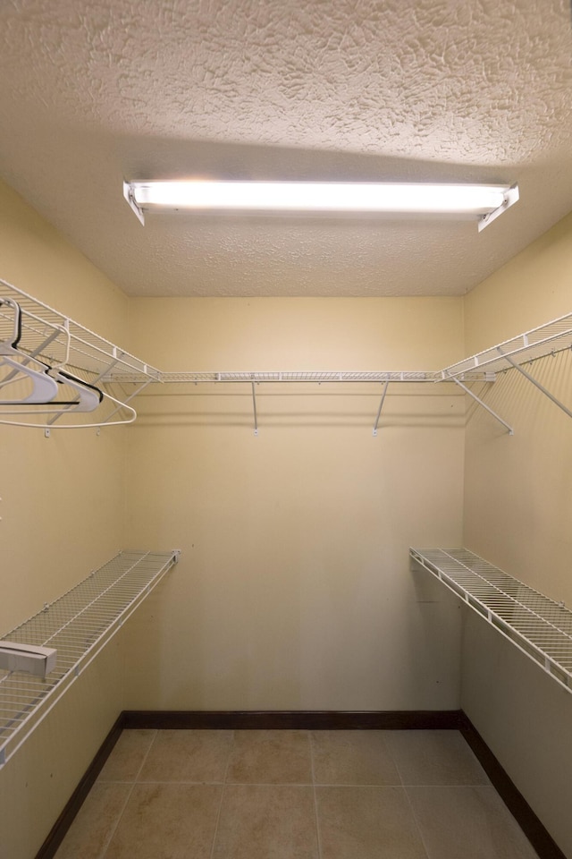 walk in closet with tile patterned flooring