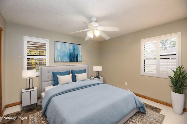 bedroom with multiple windows, baseboards, and a textured ceiling