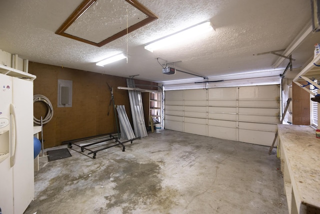 garage featuring white refrigerator with ice dispenser and a garage door opener