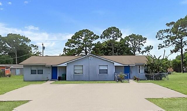 single story home with a front yard, stucco siding, and central AC
