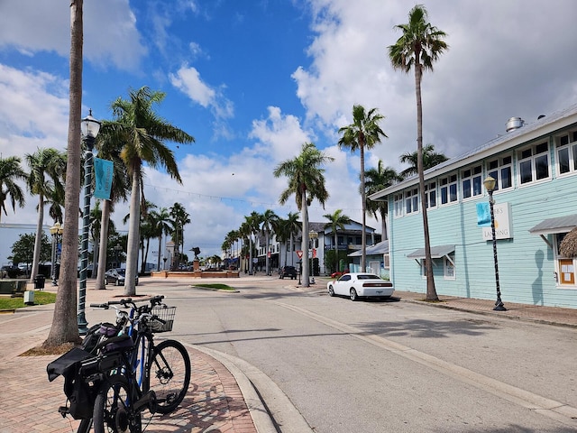 view of street with street lights, sidewalks, and curbs