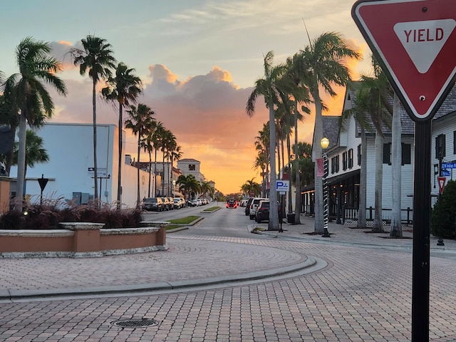 view of road with street lights, sidewalks, curbs, and traffic signs