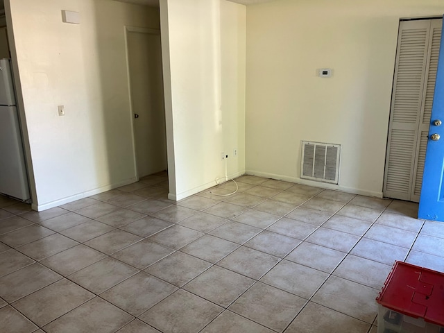 tiled spare room featuring visible vents and baseboards
